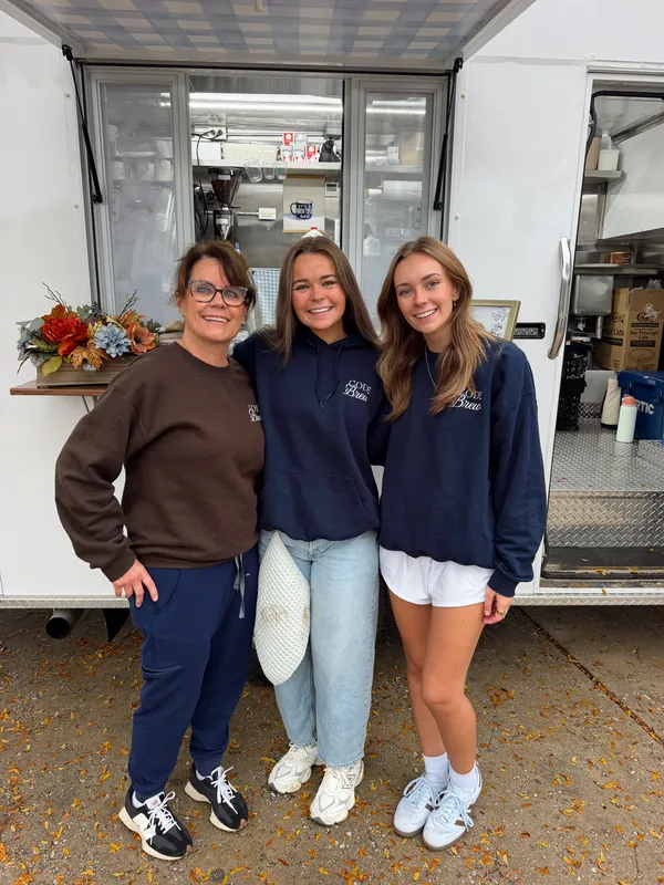 Three of the Code Brew crew in Code Brew sweatshirts in front of the open truck