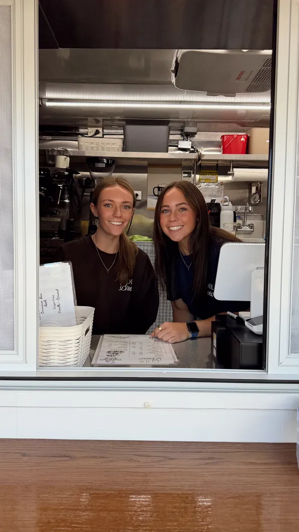 Two of the Code Brew crew smiling from the service window
